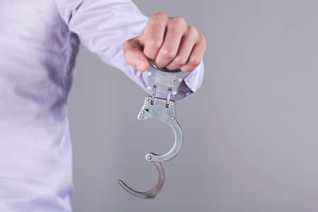 man hand handcuffs in back on the dark backgroundの写真素材
