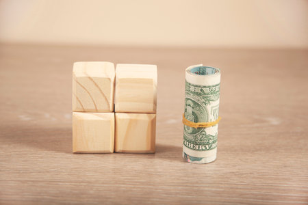 dollar and wooden Architectural cubes on tableの写真素材