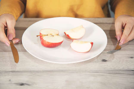 woman hand apple on white plate on tableの写真素材