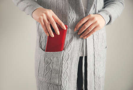 woman hand phone in pocket on gray backgroundの写真素材