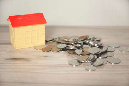house model on with coins on deskの写真素材
