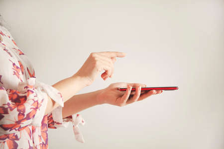 woman hand holding smart phone on gray backgroundの写真素材