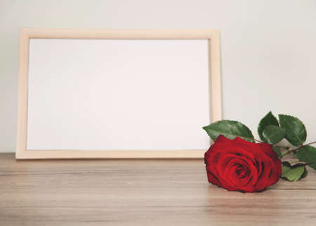 red rose and photo frame on the tableの写真素材