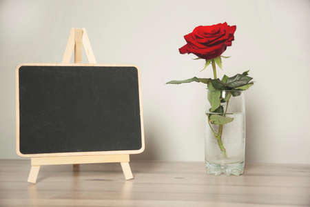 red rose and chalkboard on the deskの写真素材