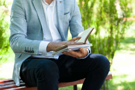 man hand pen with notepad in the park backgroundの写真素材
