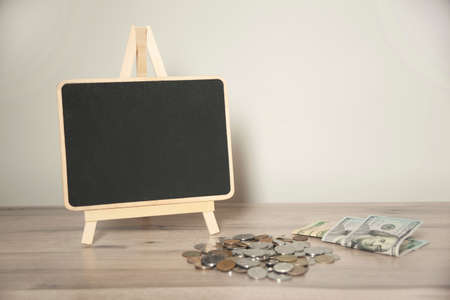 with coins and chalkboard on the deskの写真素材