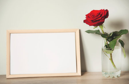 red rose and photo frame on the table