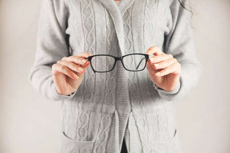 woman hand glasses on gray backgroundの写真素材