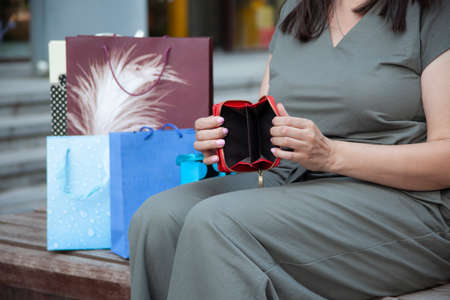 Open the empty wallet after shopping of woman carrying color paper bag.の写真素材