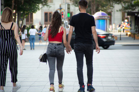 couple hand in hand walking in street