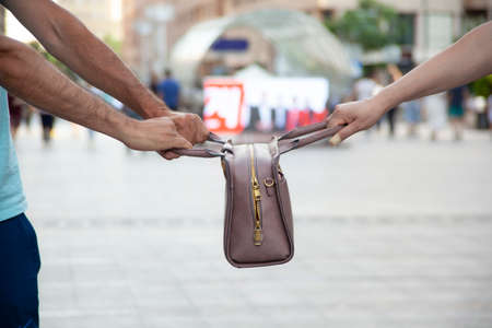 woman and man pull the bag in streetの写真素材