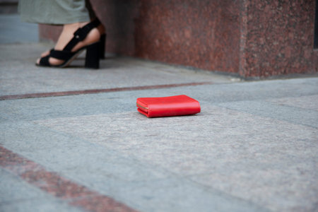 woman and a wallet on the ground in street