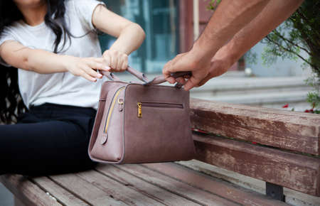 woman and man pull the bag in streetの写真素材