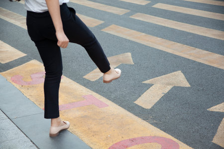 Woman walking in crosswalk in street.