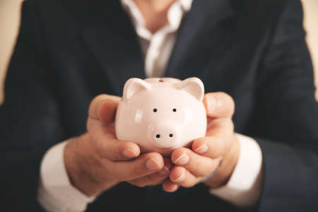 Man putting coin in piggy bank. saving money, finance conceptの写真素材