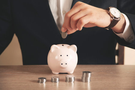 businessman hand holding coins putting in jar concept finance and accounting saving