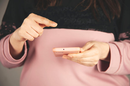 woman hand holding smart phone on gray backgroundの写真素材