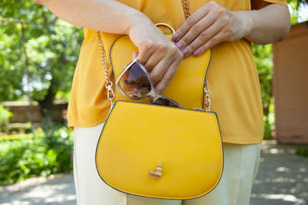 woman hand glasses in bag in the streetの写真素材