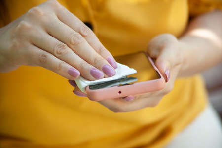 woman clean phone in napkin in the streetの写真素材