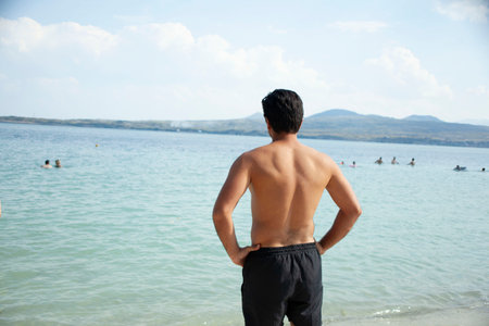 young man standing at seaの写真素材