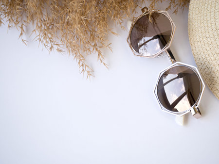 sunglasses, straw hat and dry grass top view izolated copy paste space.