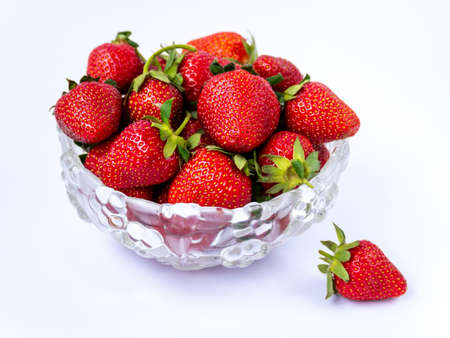 Heap of fresh ripe strawberries in glass bowl on white background, isolated.の写真素材