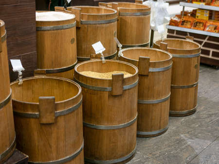 Old wooden barrels with corn, rice and buckwheat in market place.の写真素材