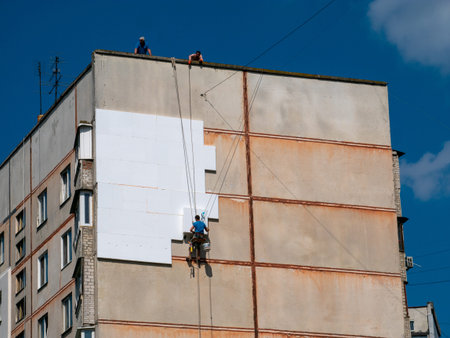 Insulation and Energy Saving Technology Concept. Worker Making Building with heat insulated facade