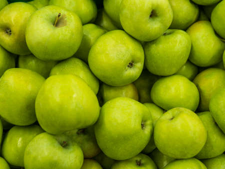 Green apples. Fitness diet detox concept. Green fresh apples harvests Close up. A backdrop of Green fresh apples. Street vegetable market. Group of Green fresh tasty apples pattern texture background.の写真素材