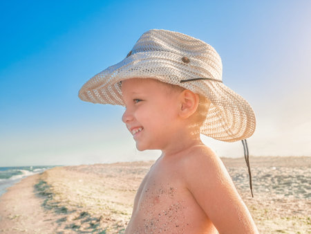 Lilltle Baby looking at the ocean, playing on the seaside in summertimes. Baby having fun with the sand. Summer rest concept. Happy childhood concepthaving fun with the sand. Summer rest concept. Happy childhood conceptの写真素材
