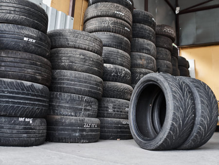 Used car tires stacked in piles at tire fitting service. Wheels for repair shop. Car service...