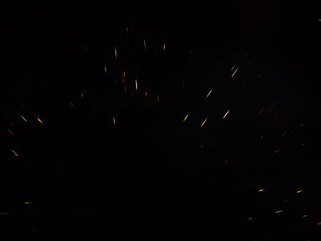 Blurred background lights. Abstract defocused gold, white, red and yellow glitters texture on black...