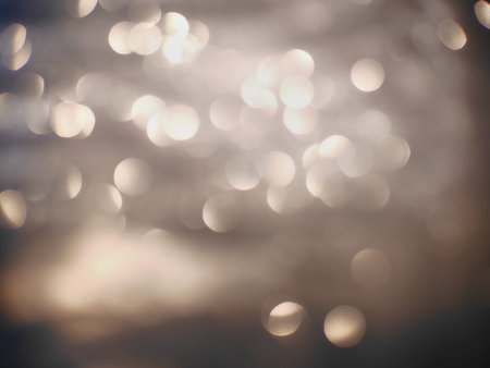 Blurred background lights. Abstract defocused gold, white, red and yellow glitters texture on black...