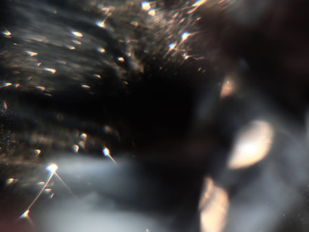 Blurred background lights. Abstract defocused gold, white, red and yellow glitters texture on black...