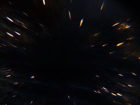 Blurred background lights. Abstract defocused gold, white, red and yellow glitters texture on black...