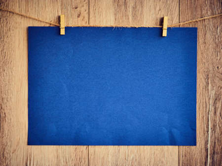 Blank for text on blue paper a wooden background. Letter on the clothespins. Vintage wooden texture. Free space. Copy Space.の写真素材