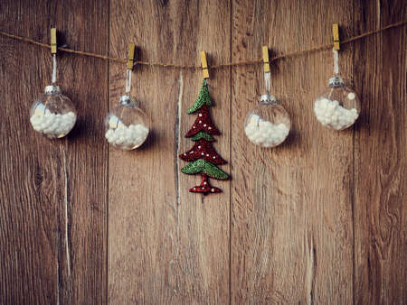 Christmas decorations: Xmas tree and snowballs on the wooden background. Christmas decorations, toys for the Christmas tree hanging on clothespins. Copy Space.の写真素材