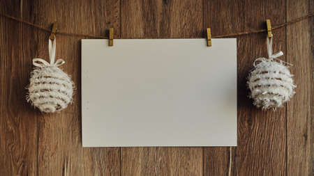 Christmas decorations on a wooden background. Vintage greeting card. New Year decorations and free space for text on a wooden background. Holidays decor on the clothespins. Vintage texture. Copy space.の写真素材