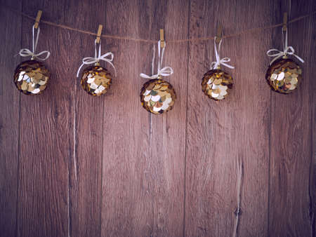 Christmas decorations on a wooden background. New Year decorations and free space for text on a wooden background. Holidays decor on the clothespins. Vintage texture.の写真素材