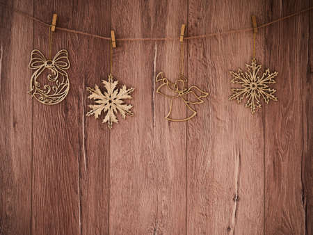 Christmas decorations on a wooden background. New Year decorations and free space for text on a wooden background. Holidays decor on the clothespins. Vintage texture.の写真素材