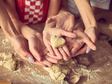 Gift of dough. Self made pastry heart. Hands with heart. Holiday concept. Valentines Day. Family conceptの写真素材
