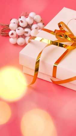St. Valentine day background. Gift box with gold ribbon and lights on a pink background. Holiday background.の写真素材