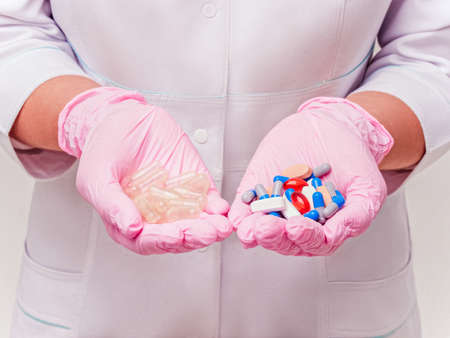 Placebo drugs concept. Doctor holds pills and placebo's. Hand in pink Gloves with Pills. Empty pills. Healthcare concept Laboratory Reserch. Pharmacy biotechnology science. Hand in pink Gloves with Pill. Healthcare conceptの写真素材