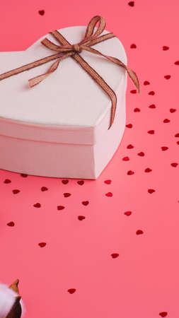 St. Valentine day background. Gift box with gold ribbon and lights on a pink background. Holiday background.の写真素材