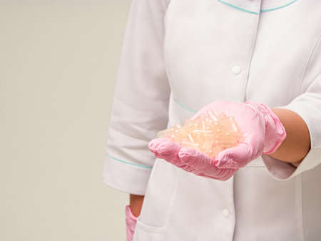 Placebo effect concept. Doctors hand giving a heap of empty pills capsules with placebo effect on white backgroundの写真素材