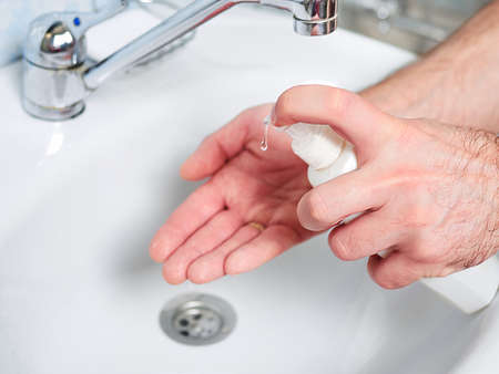Hygiene concept. Washing hands with soap under the faucet with water. Coronavirus protectionの写真素材