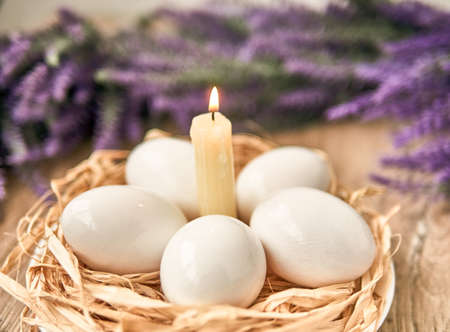 White Easter eggs with lighting candle. Happy Easter Concept. Congratulations Easter cardの写真素材