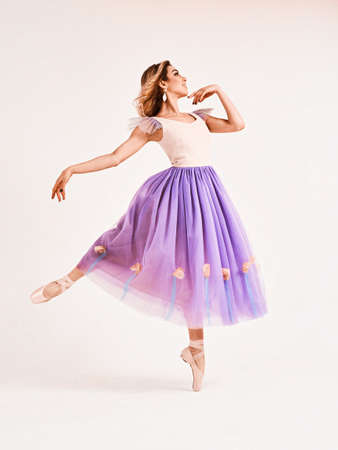 Ballet dancer or classic ballerina dancing isolated on white studio background. Woman with the violet cloth. The dance, grace, artist, contemporary, movement, action and motion conceptの写真素材