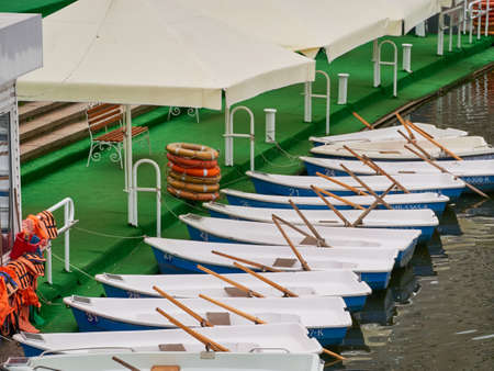 Boats on the river. pier with boats. Boat for walking. Boat rental. Relax in the summer. Outdoor recreation. Rest away from the city. Comfortable boat with leather seats.の写真素材