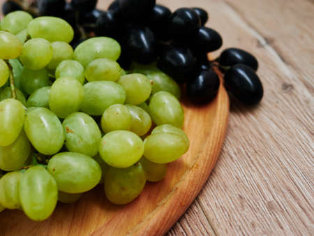 Healthy fruits. Red and green wine grapes on wooden background, dark and green organic wine grapes. Red Grape in a supermarket local market bunch of grapes ready to eat.の写真素材